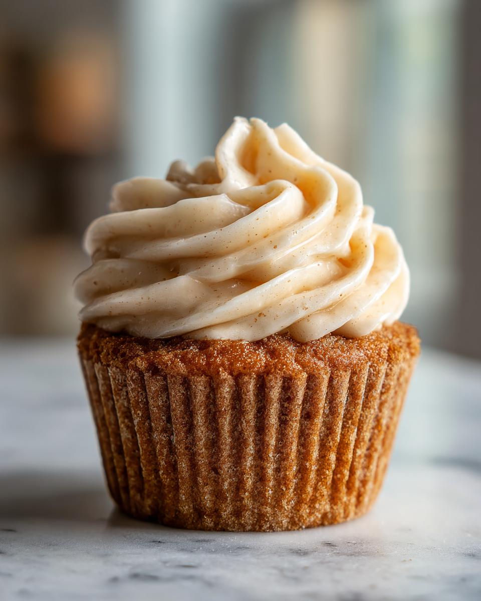 Close-up of a birthday cupcake with a swirl of creamy frosting on top.