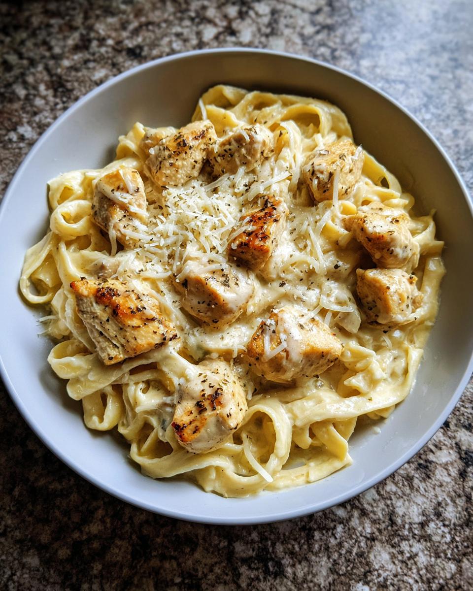 Bowl of creamy chicken pasta, a delicious option for keto dinner recipes, topped with parmesan and herbs.