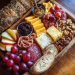 A bountiful Fall Harvest Cheese Board featuring an assortment of cheeses, salami, grapes, nuts, apples, and bread.
