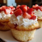 Close-up of delicious Mini Strawberry Shortcake Cupcakes topped with whipped cream and fresh strawberries.