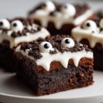 Close-up of delicious Monster Brownies (halloween) decorated with white frosting and candy eyes.