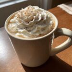 Close-up of a creamy Pumpkin Spice Latte topped with whipped cream and a sprinkle of cinnamon.