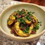 A bowl of roasted delicata squash salad with pecans and fresh parsley.