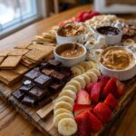 An abundant S'mores Dessert Board featuring graham crackers, chocolate, marshmallows, peanut butter, chocolate spread, strawberries, and bananas.