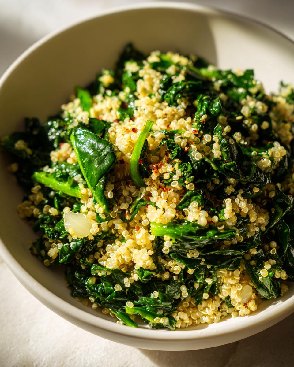 Close-up of a healthy bowl of quinoa mixed with wilted greens and red pepper flakes, part of the evergreen 2024 recipe.