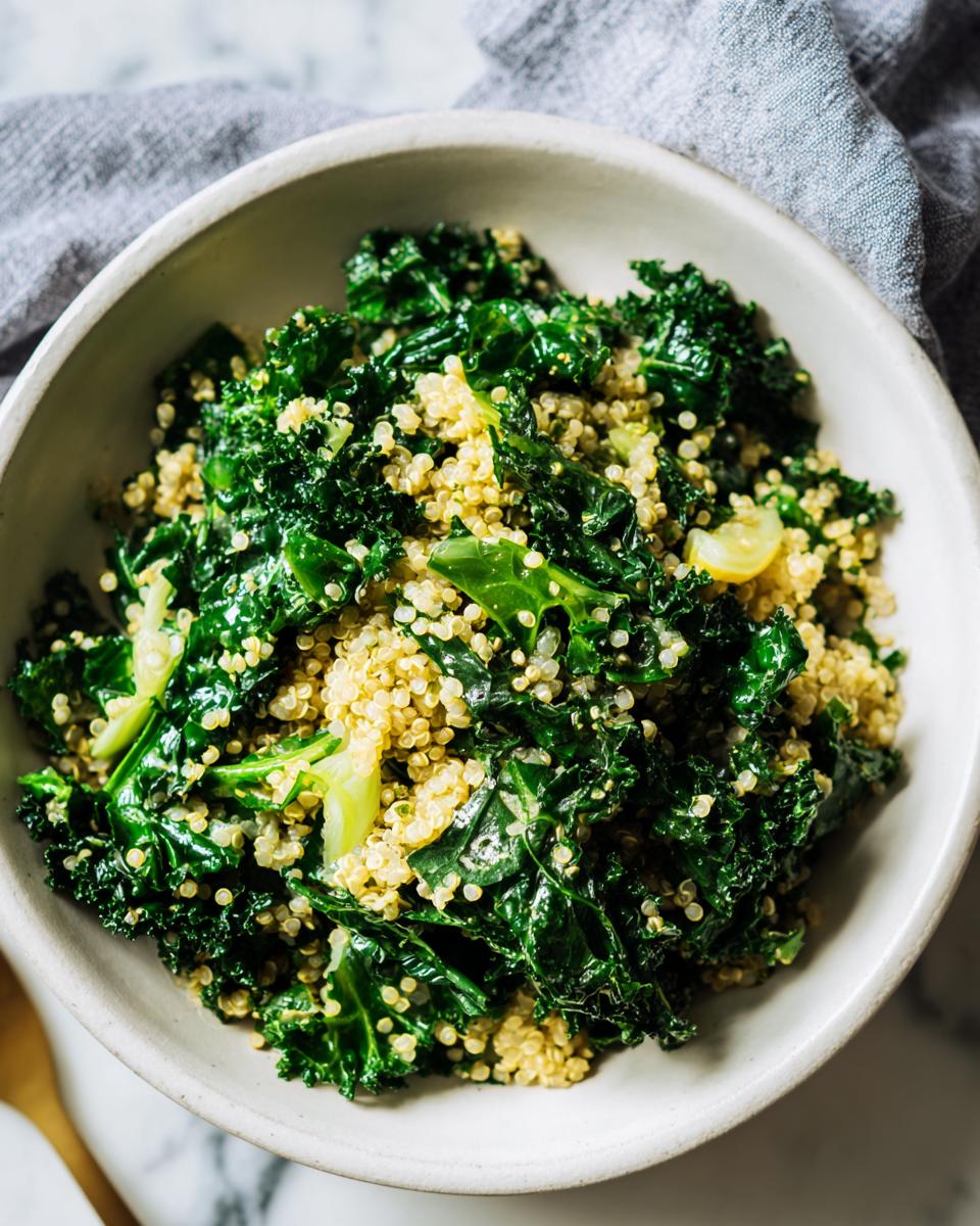 A close-up of a white bowl filled with a vibrant mix of cooked quinoa and fresh kale, part of the evergreen 2024 recipe.