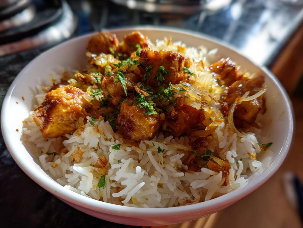 Bowl of chicken and rice recipes with seasoned chicken, white rice, and fresh herbs on top.