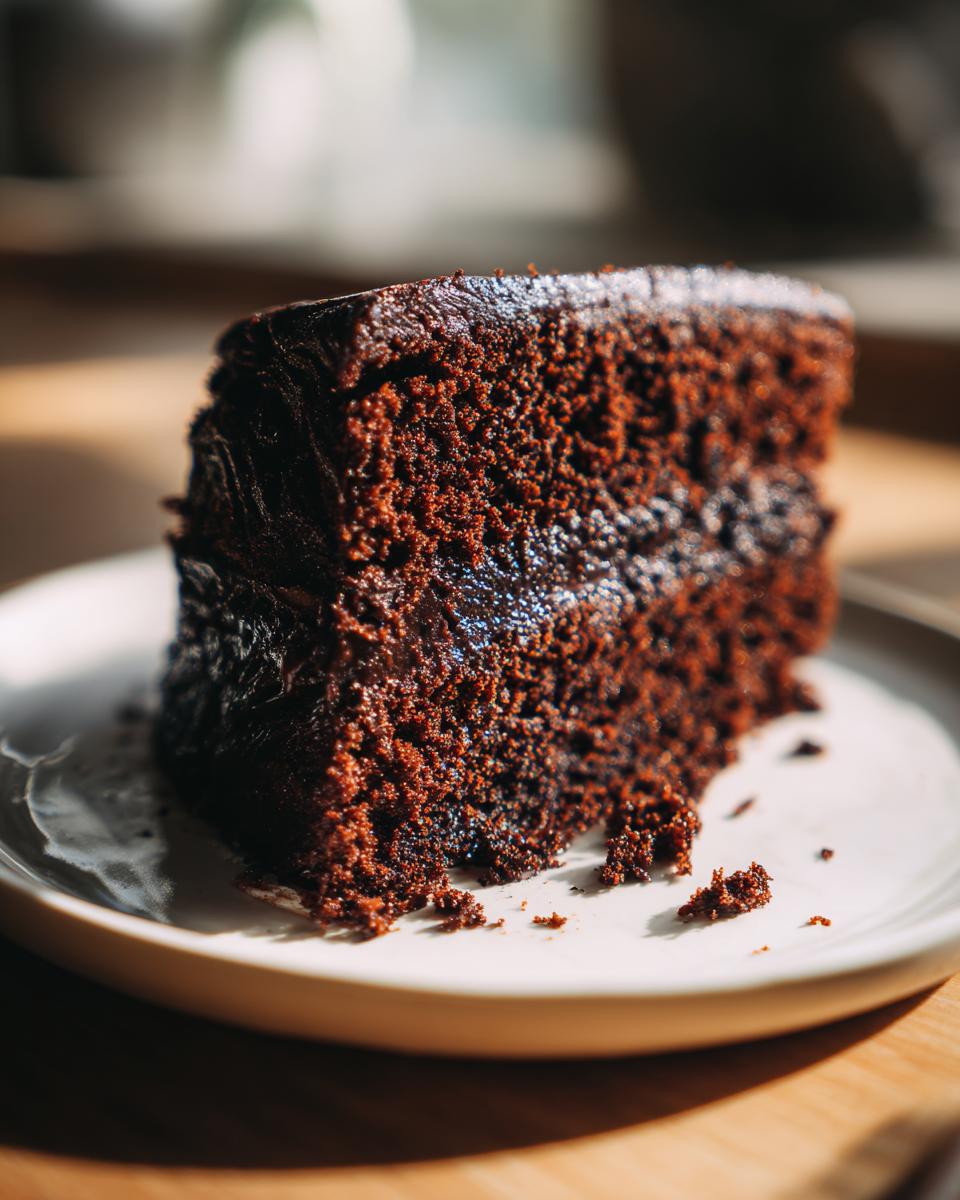 A decadent slice of moist chocolate cake with rich frosting, perfect for the 1-bowl chocolate cake recipe.