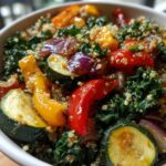 Bowl of kale quinoa salad with roasted vegetables including zucchini, bell peppers, and red onion.