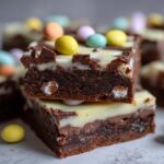 Close-up of layered chocolate Easter desserts topped with colorful candy-coated chocolates.