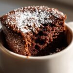 Close-up of a chocolate mug cake topped with powdered sugar in a white mug, easy dessert recipes