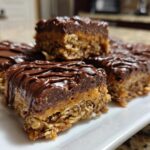 Close-up of no bake dessert recipes chocolate bars with oats and drizzled chocolate topping