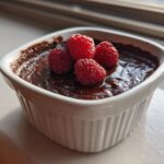 White ramekin filled with easy chocolate dessert topped with fresh raspberries