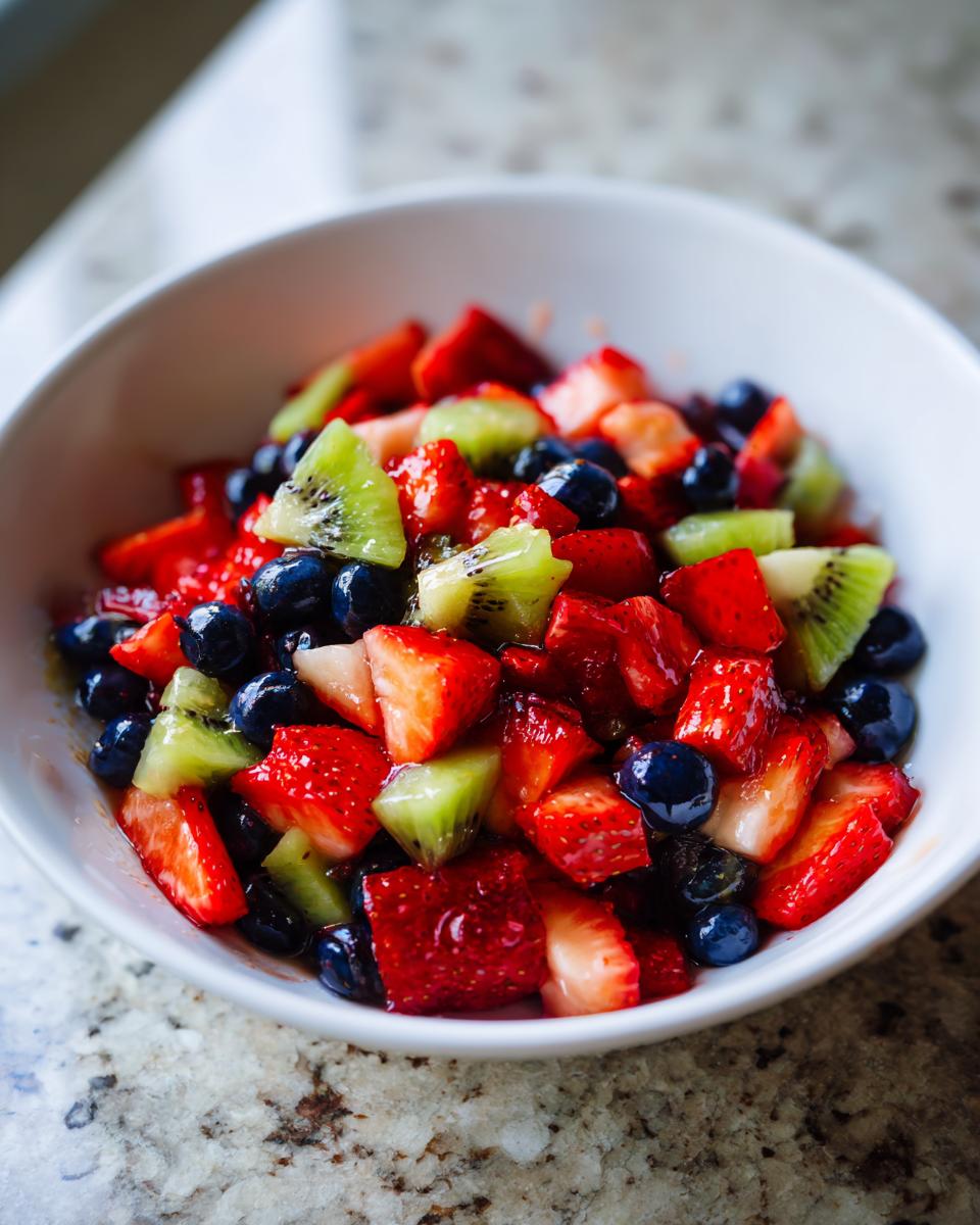 Bowl of fresh mixed fruit with strawberries, blueberries, and kiwi for fruit dessert recipes