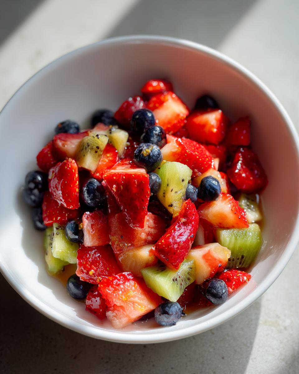 Bowl of fresh fruit salad with strawberries, blueberries, and kiwi for fruit dessert recipes