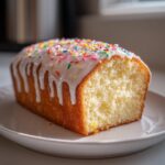 Close-up of iced pound cake with colorful sprinkles on a white plate, Easter dessert recipes