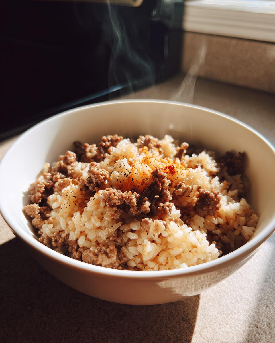 Steaming bowl of rice mixed with ground beef seasoned with spices, a one pot dinner recipes dish.