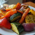 Plate filled with roasted vegetable recipes including zucchini, bell peppers, carrots, and onions.